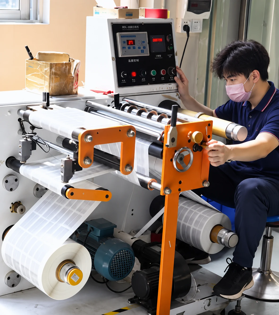 Operator handling roll material at converting equipment